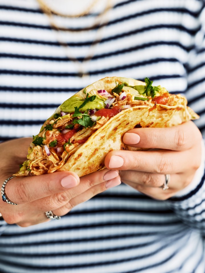 Hands holding a chicken taco.