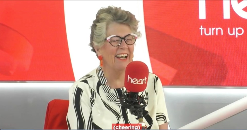 Prue Leith laughing while speaking into a Heart radio microphone.