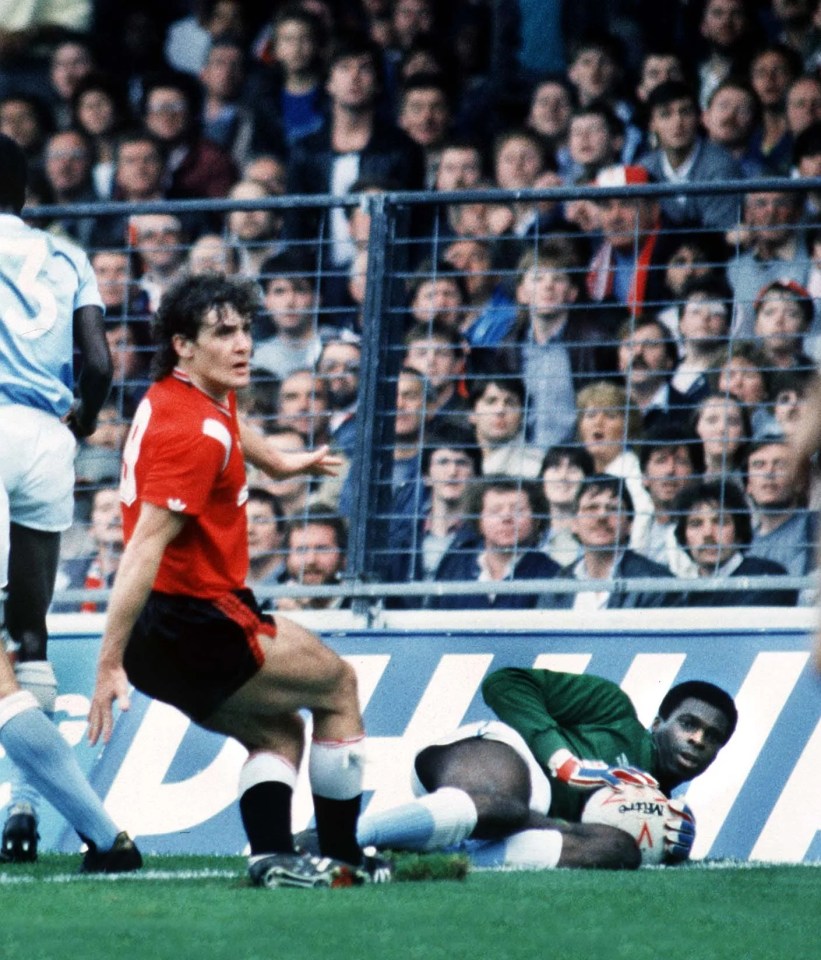 Manchester United's Mark Hughes and Manchester City's goalkeeper Alex Williams during a 1985 match.