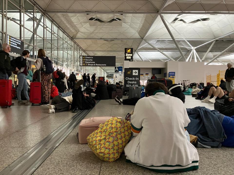 Passengers sleeping on the floor of Stansted Airport before an early flight.