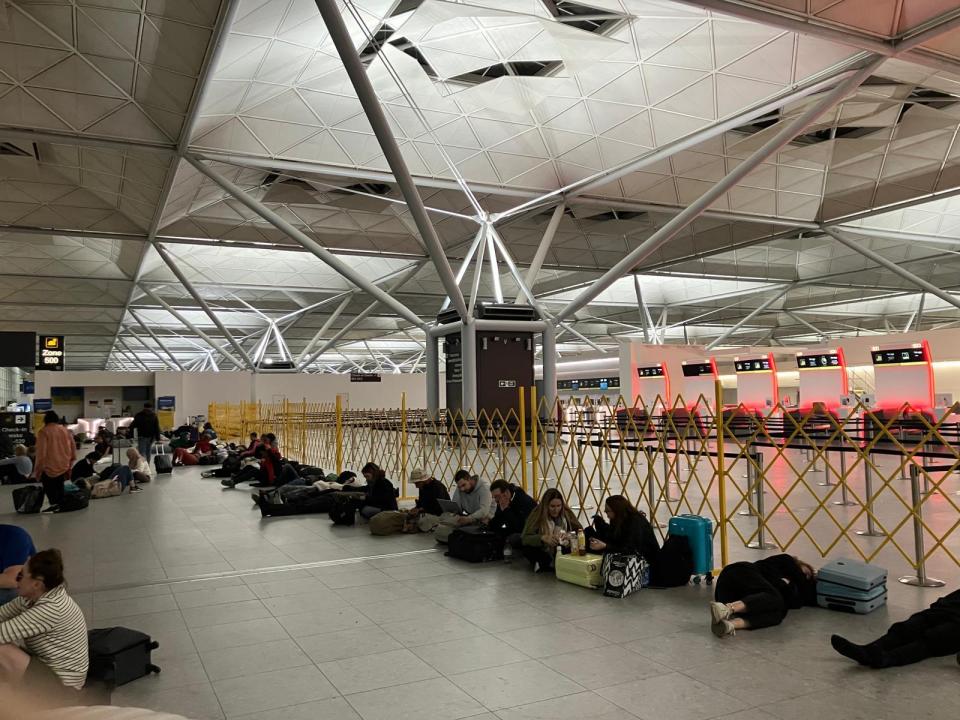 Passengers sleeping on the floor of Stansted Airport before an early flight.