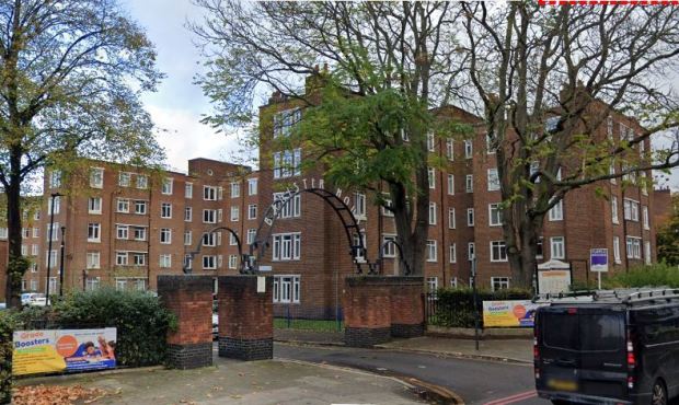 Brick apartment building with arched entrance.