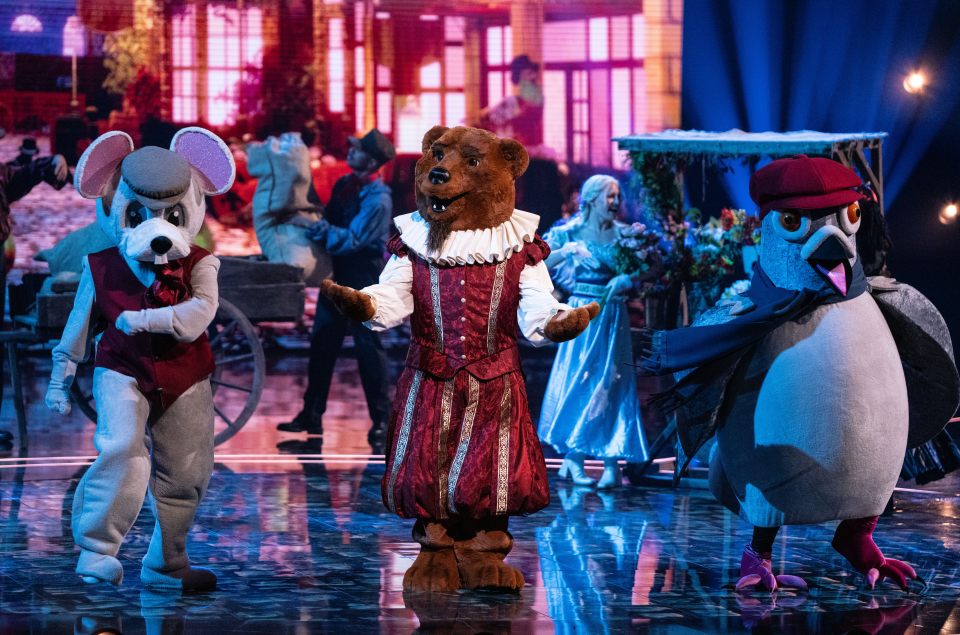 Costumed performers dressed as a mouse, bear, and pigeon on a stage.