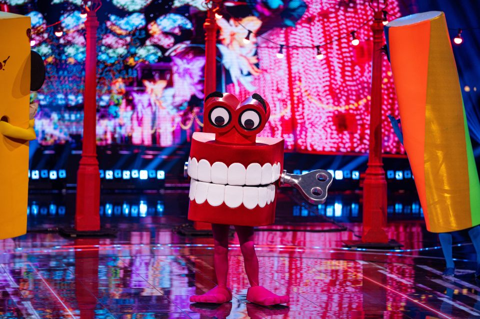 A contestant dressed as a set of chattering teeth on a stage.