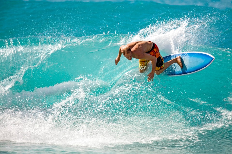 Surfer riding a wave in Barbados.