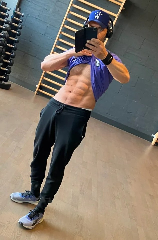 Man showing off his eight-pack abs in a gym selfie.