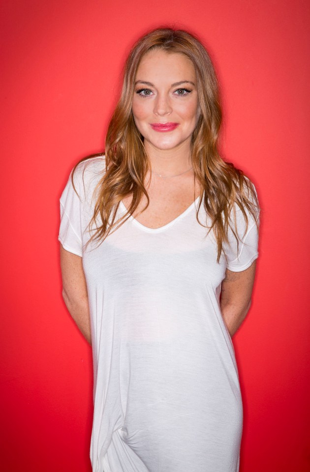 Lindsay Lohan in a white shirt against a red background.