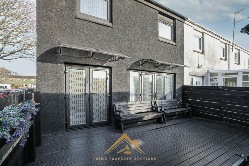 Black house exterior with black deck and benches.