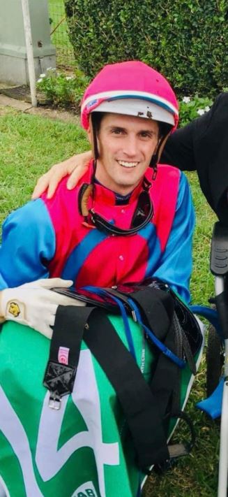 Jockey in pink and blue silks.