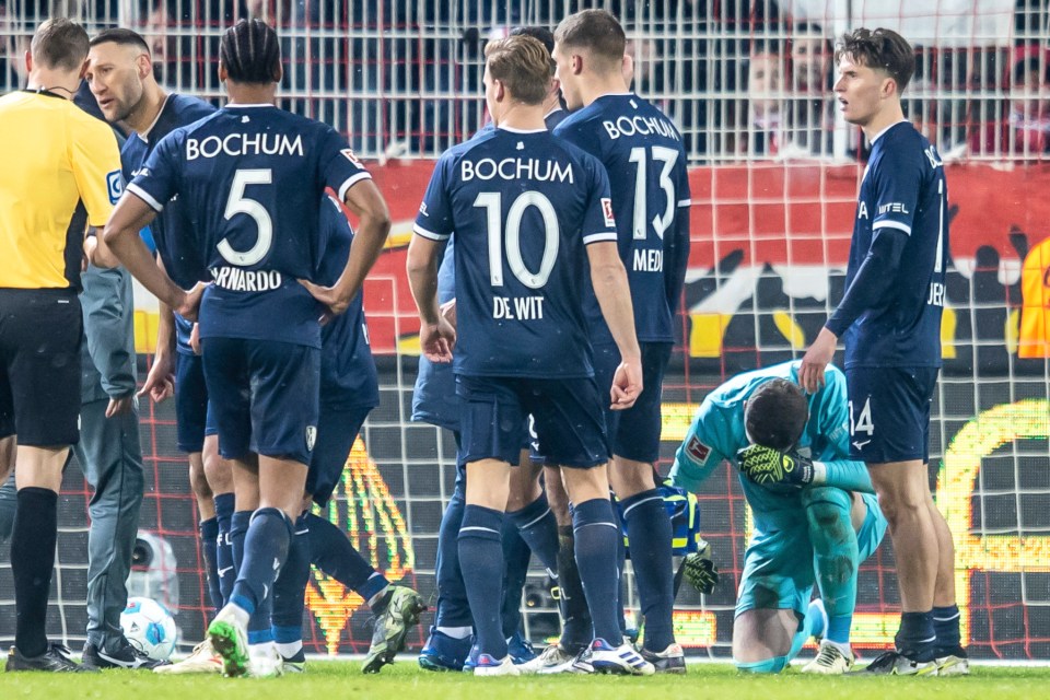 Bochum goalkeeper Patrick Drewes kneels after being hit.