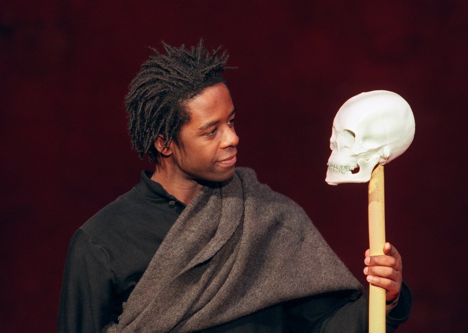 Adrian Lester as Hamlet holding a skull.