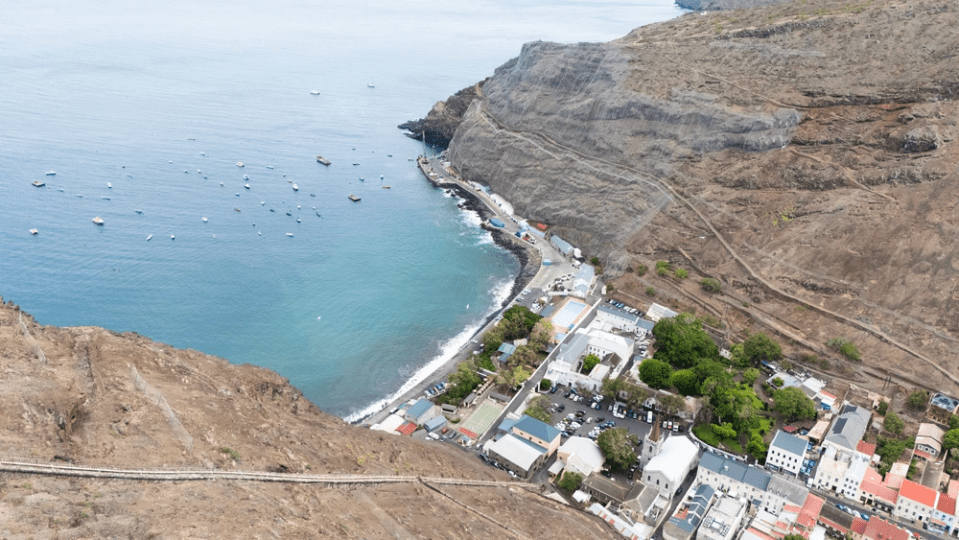 Aerial view of a coastal town with boats in the bay.