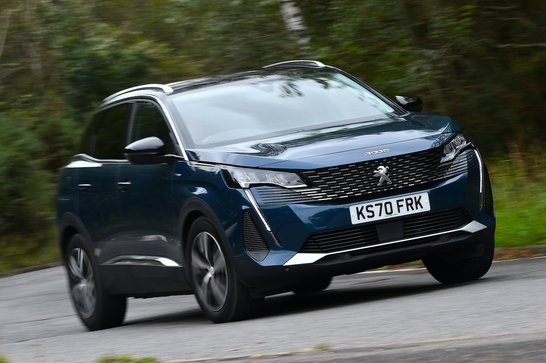 A dark-blue Peugeot 3008 driving on a road.