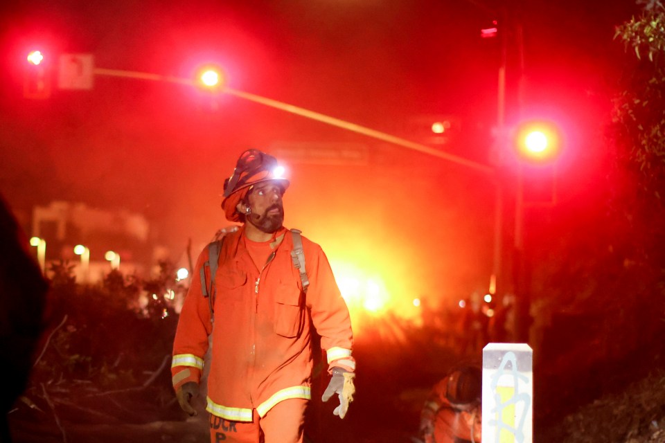 Firefighter walking at night during a fire.