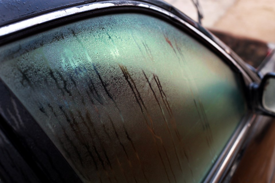 Close-up of a car window covered in condensation on a cold day.