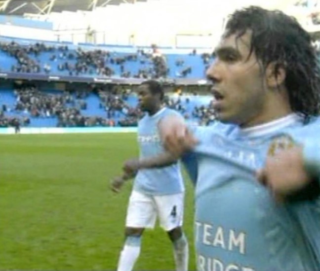 Carlos Tevez taking off his Manchester City jersey.