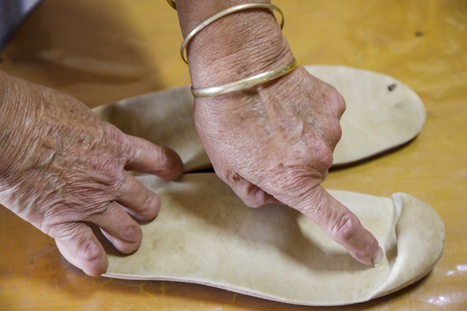 Woman with prosthetic fingers adjusting shoe inserts.