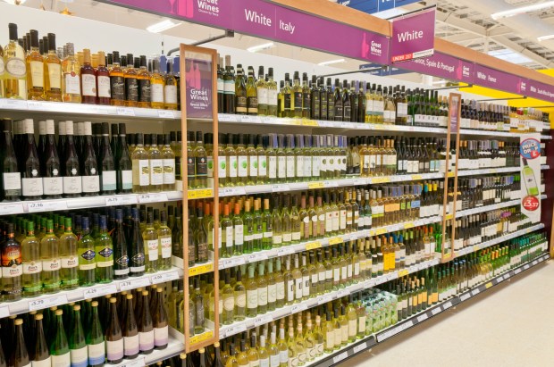 White wine bottles on shelves in a supermarket.