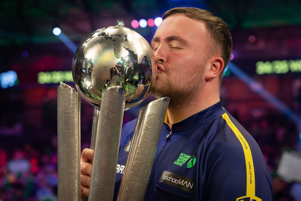 Luke Littler kisses the Sid Waddell trophy after winning the World Darts Championship.