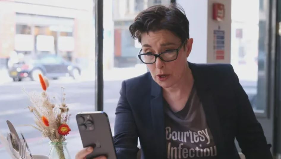 Sue Perkins looking at a smartphone.