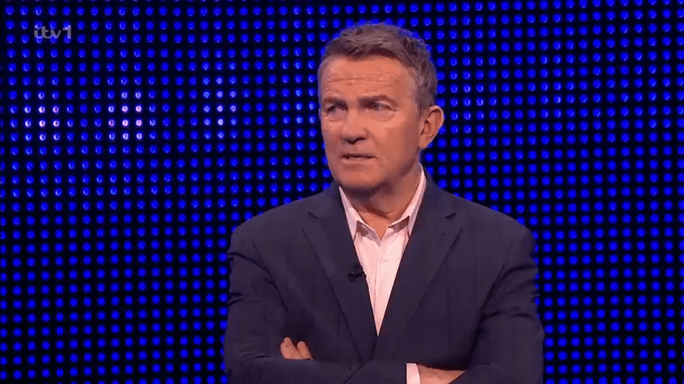 The Chase host with arms crossed.