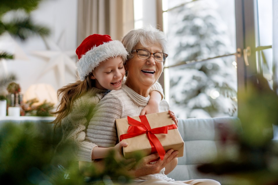 Grandmother and granddaughter exchanging Christmas gifts.