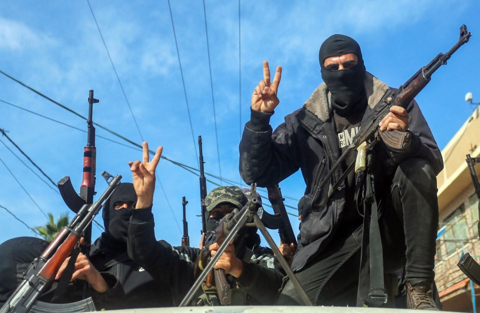 Armed civilians celebrating a ceasefire, making peace signs.