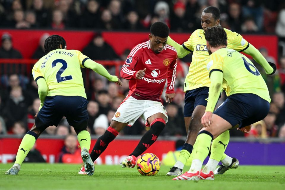 Amad Diallo of Manchester United dribbling the ball, surrounded by Southampton players.