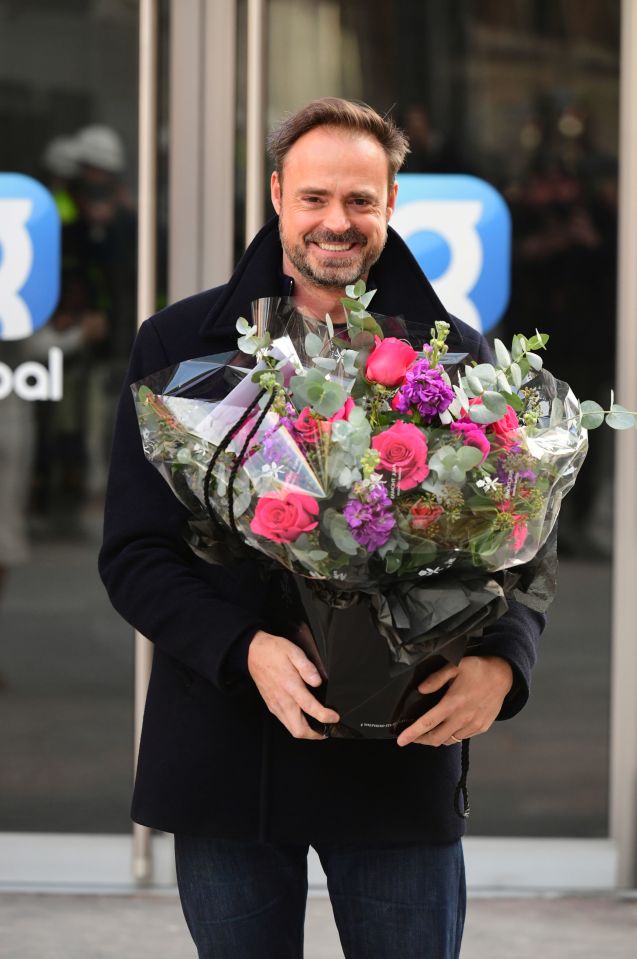 Jamie Theakston holding flowers outside Global Radio studios.