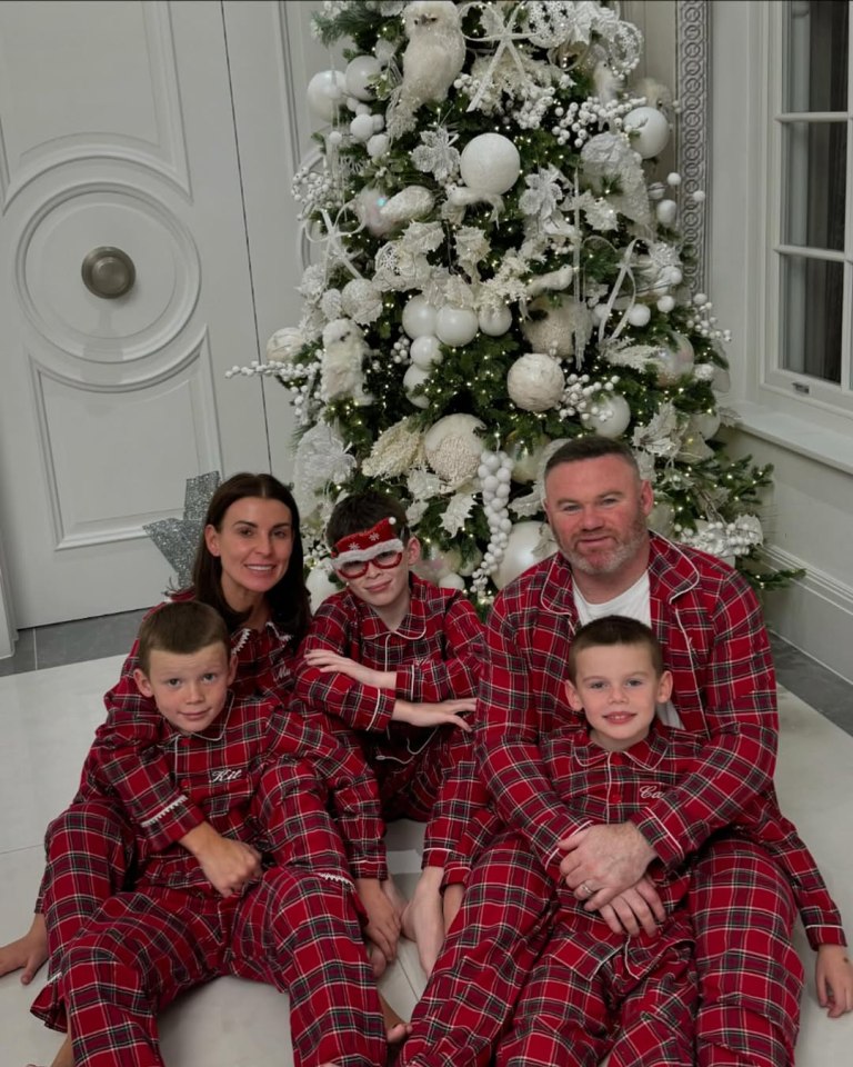 The Rooney family in matching Christmas pajamas in front of a decorated Christmas tree.