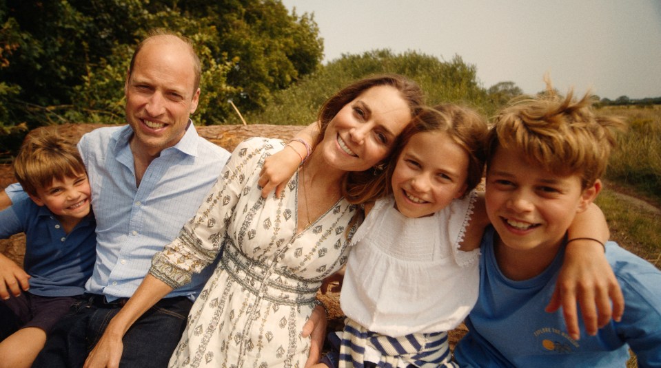 Prince William, Princess Catherine, and their three children smiling for a family photo.