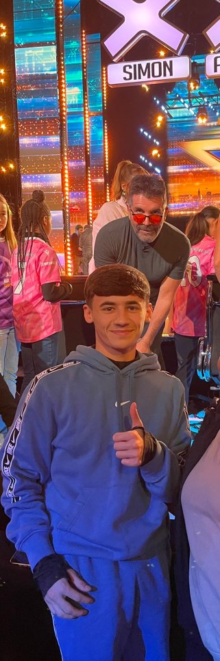 Kyran Bowes, Coronation Street teen star, gives a thumbs-up next to Simon Cowell on the Britain's Got Talent set.