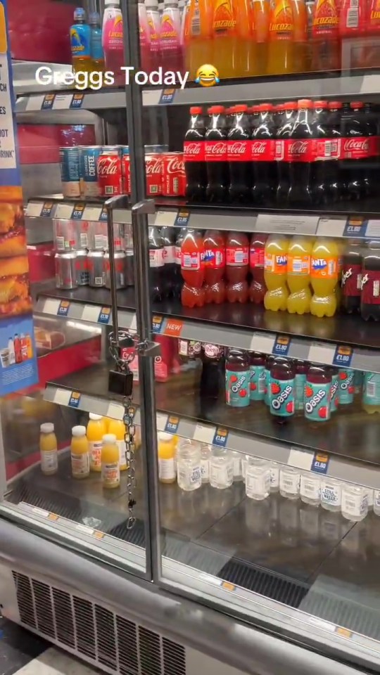 Refrigerated display case in Greggs with various drinks locked up.