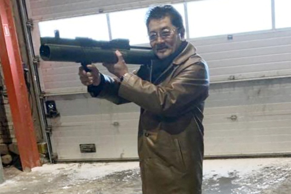 Man holding a rocket launcher in a warehouse.