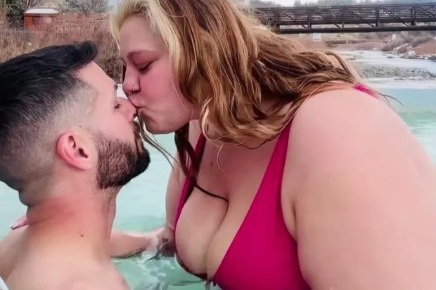 A plus-size woman and a smaller man kissing in a hot tub.  The text overlay reads, &quot;It's okay to be bigger than your partner.&quot;