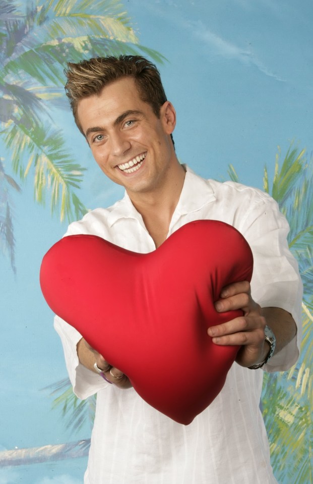 Man holding a heart-shaped pillow.