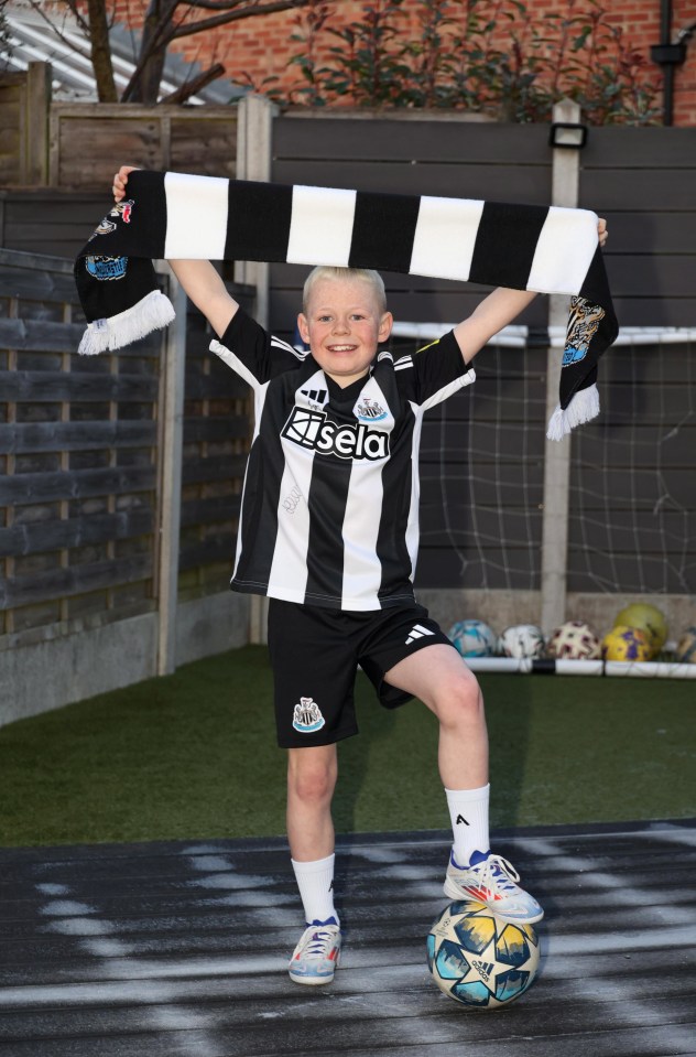 Nine-year-old Sammy Scott in Newcastle United kit, holding a team scarf, with a football.