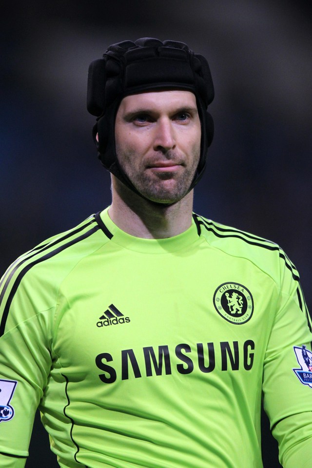 Petr Cech, Chelsea goalkeeper, wearing a protective headguard and lime green goalkeeper jersey.