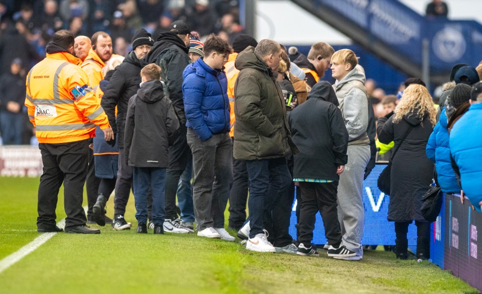 A soccer game is delayed due to a medical emergency in the stands.