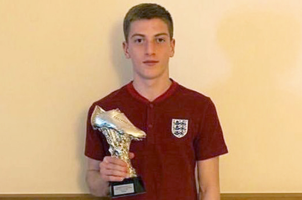 Liam Delap holding a soccer boot trophy.