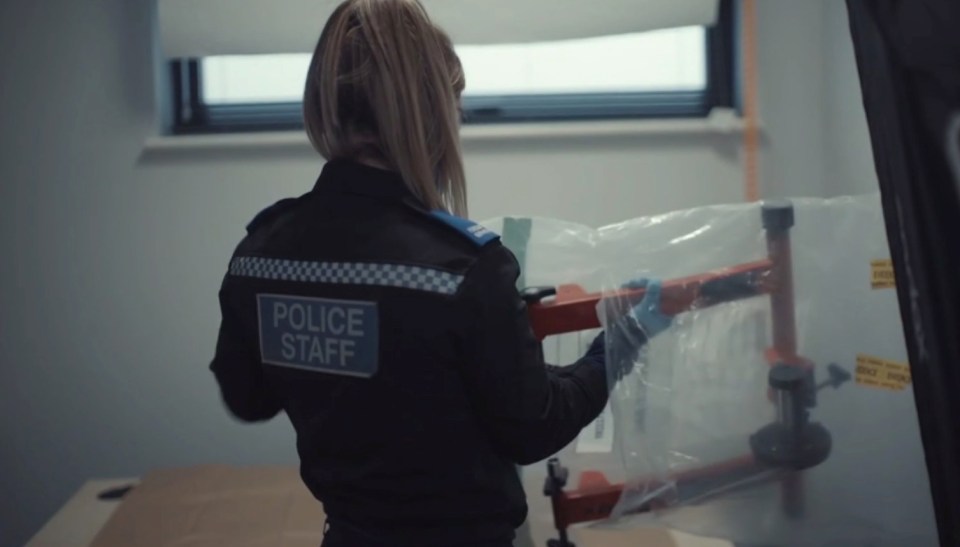 Police officer weighing drugs seized in a drug bust.