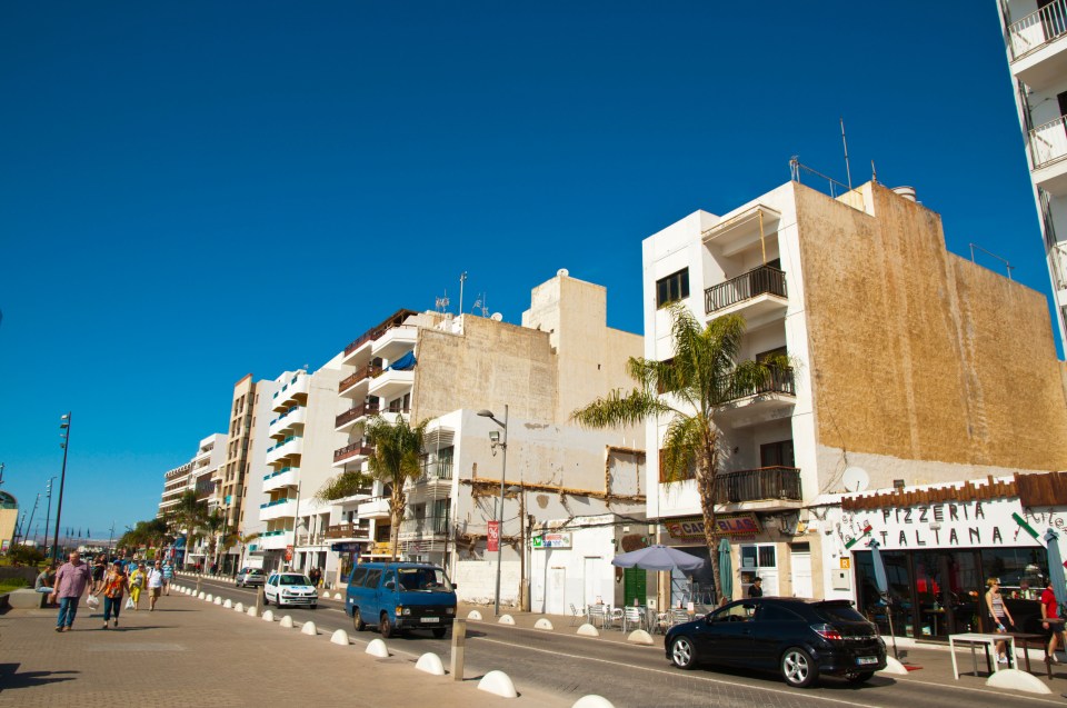 Street scene in Arrecife, Lanzarote, with buildings, cars, and pedestrians.