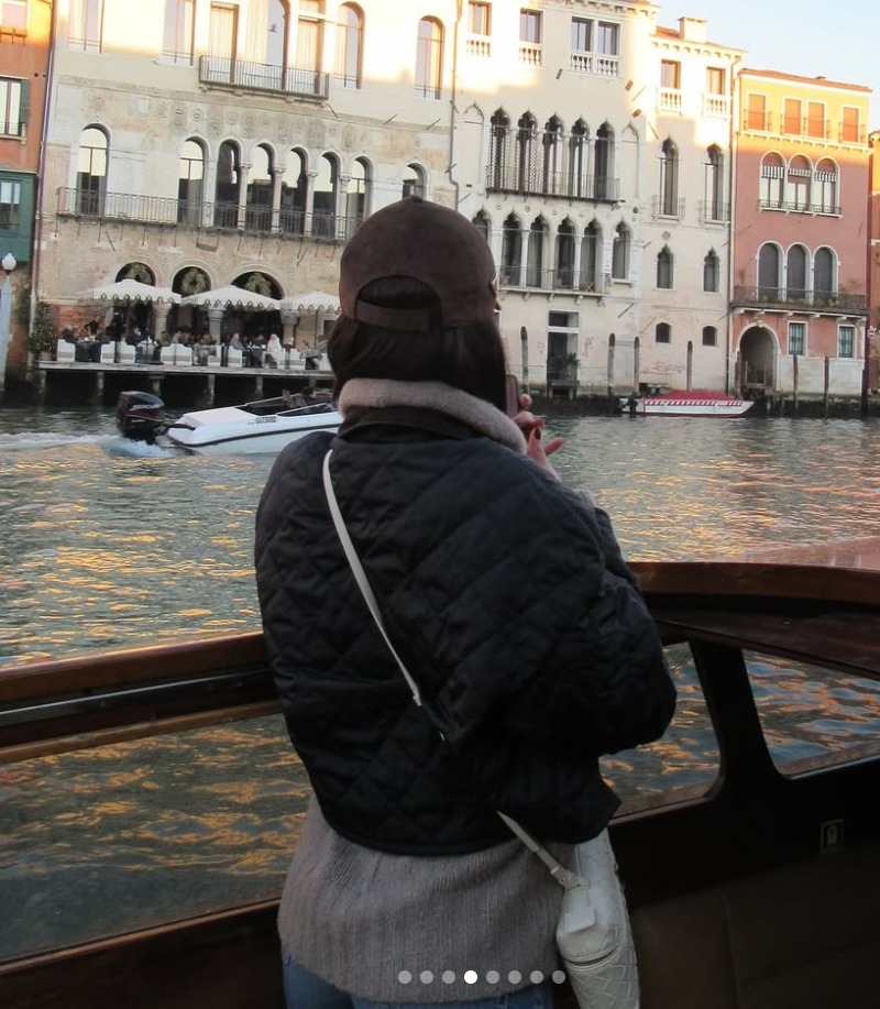 Person on a boat looking at Venetian buildings.