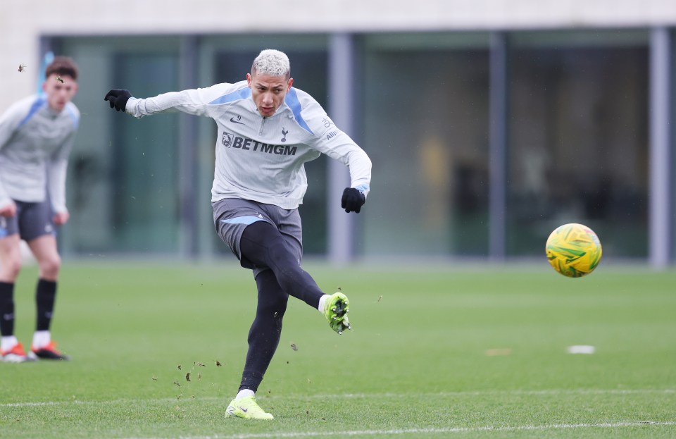 Richarlison of Tottenham Hotspur kicking a soccer ball during training.