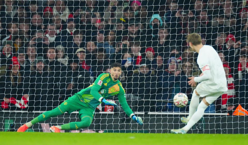 Manchester United goalkeeper Altay Bayindir diving to save a penalty kick.