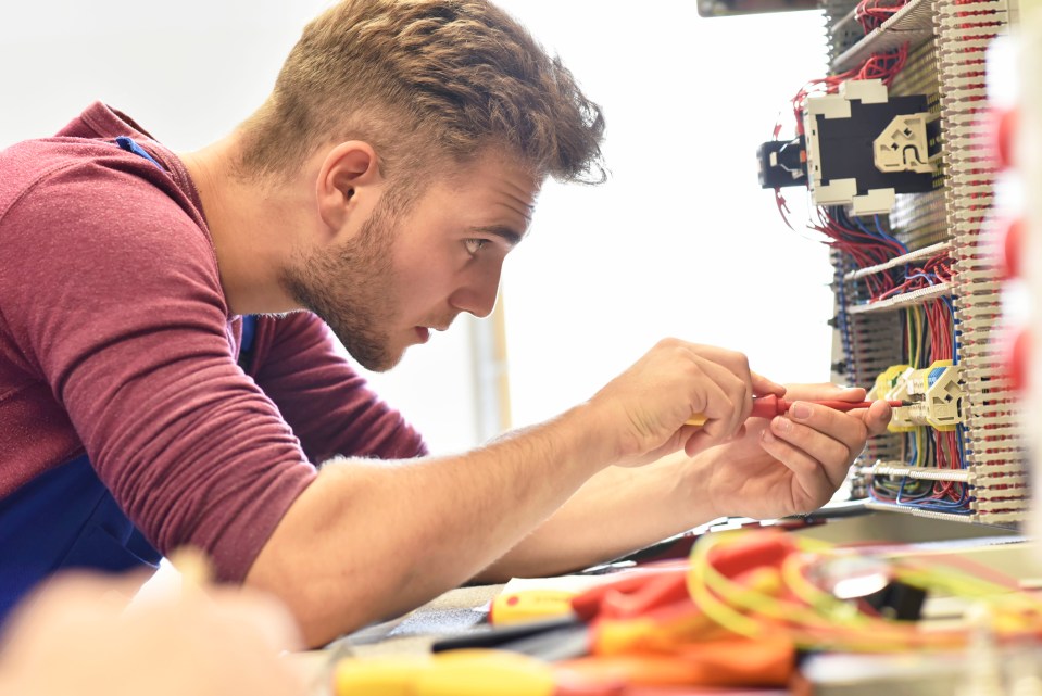 Electrician student working on an electrical panel.