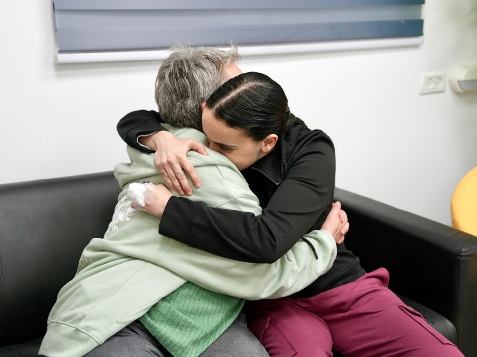 A woman embraces her mother after a reunion.