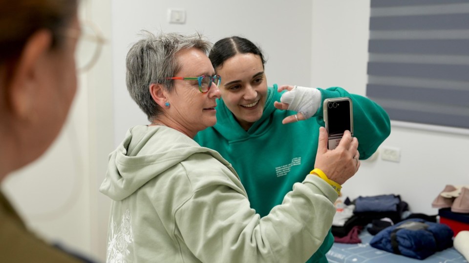 A mother and daughter reunite and take a selfie.