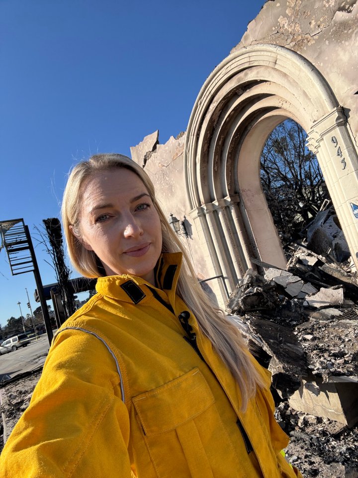 Reporter in yellow jacket at fire-damaged building.