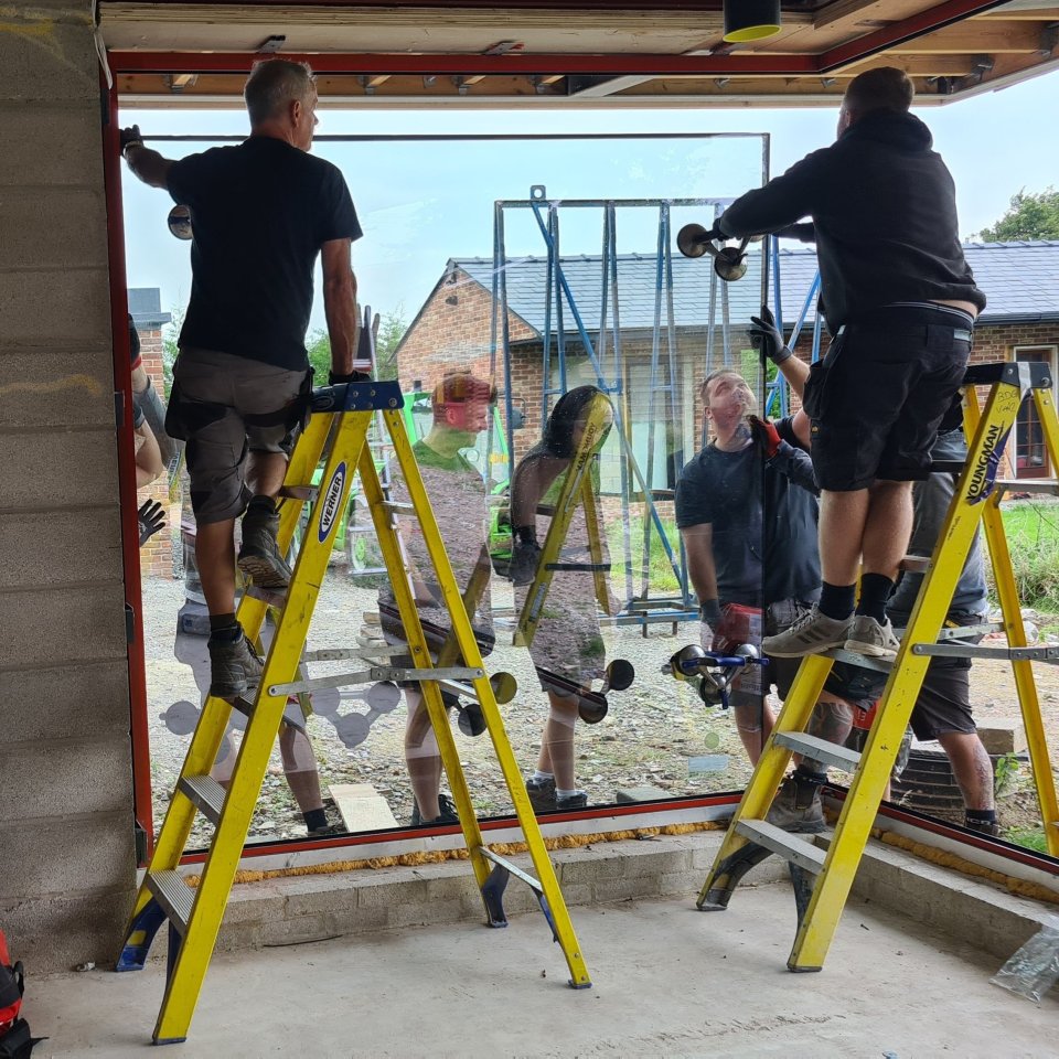 Workers installing a large window.